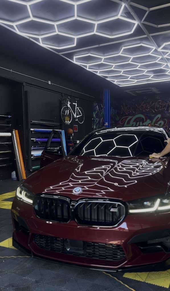 Red BMW receiving detailing work inside the shop